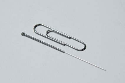 A scale comparison of an Acupuncture needle and a paperclip